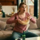 Chica delante de la TV sorprendida con popcorns