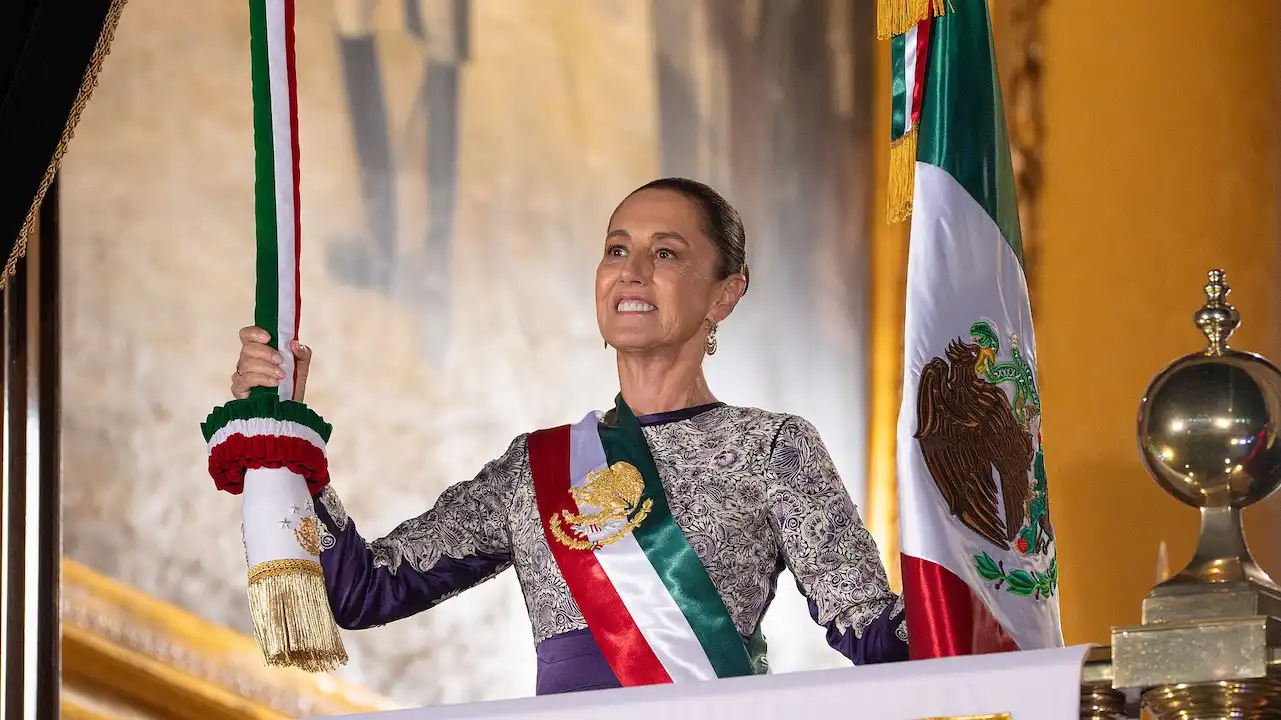 Claudia Sheinbaum tirando bandera mexicana