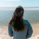 Daniella Bustamante de espaldas mira el mar
