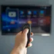 Mano con mando delante de Smart TV