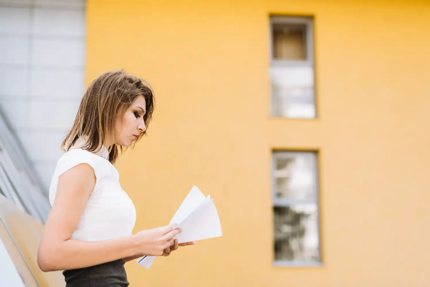 Mujer con papeles delante de casa