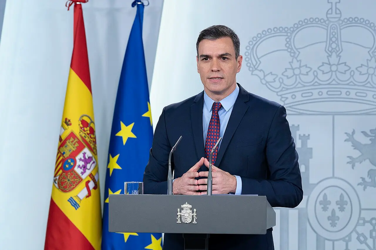 Pedro Sanchez atril banderas hablando