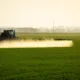Tractor echando pesticidas en un campo cultivado